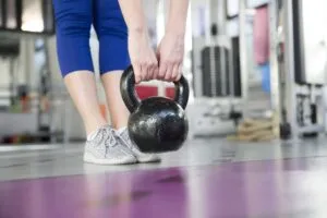 Chica levantando pesas en un gimnasio Chica levantando pesas en un gimnasio